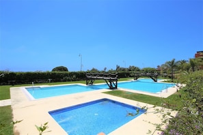 Large community swimming pool with separate childrens pool beside the beach