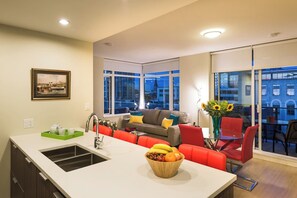 Comfy couch to snuggle in on a rainy day. Bar top seating for 4. Large spacious island for prep. Deep double kitchen sinks, ample windows for light and cross breezes on warm summer nights. 