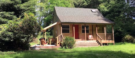 Cabin with side patio; photo taken from fire pit area in front yard