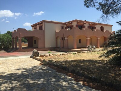 Villa individual con cancha de tenis y jardín.