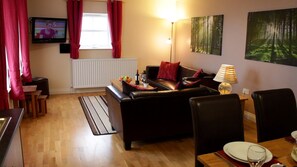 Spacious living area in Maggie's Mews with triple aspect windows, light and airy