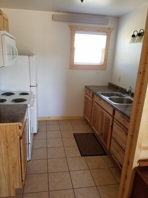 The kitchen has all the necessary dishes, utensils, and pots & pans.