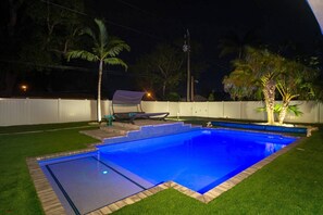 Beautiful evening lighting in pool and underneath trees.