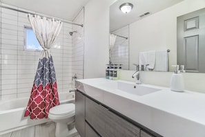 The updated bathroom offers a tub/shower combo and floating vanity.
