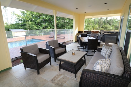 Large covered lanai with outdoor kitchen and dining - lap pool in the background