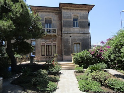 Apartamento en Villa Liberty con jardín con vistas al Etna y cerca del mar.