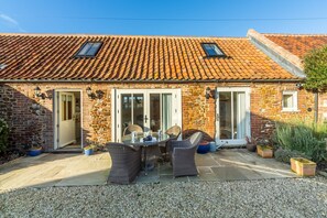 The Little Barn, Ringstead: South facing courtyard garden with dining furniture