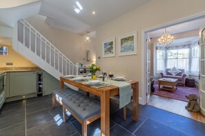 Ground floor: Dining table, french doors leading into sitting room and stairs to first floor