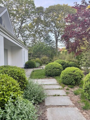 Mature landscaping on 1 acre property with fencing and front gate.