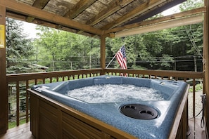 large hot tub on covered deck.