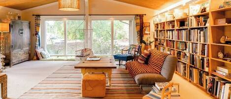 Spacious and bright living room filled with books.