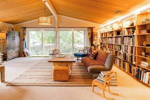Spacious and bright living room filled with books.