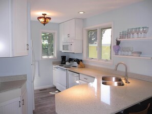 Newly remodeled kitchen with quartz countertops and recycled beach glass