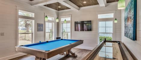 Pool table and shuffleboard table in main living room, french doors to pool