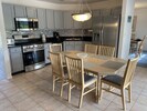 Fully equipped eat-in kitchen with stainless steel appliances & seating for six.