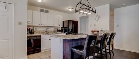 My favorite part of the house!. New kitchen with shiny granite and bar seats!