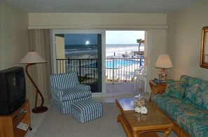 THIS IS A VIEW OF THE POOL THROUGH THE LIVING ROOM