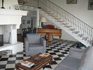 Le salon, son piano et l'escalier permettant d'accéder à l'étage