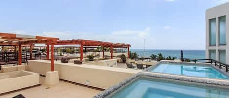 An incredible private roof terrace w/pool, loungers, shaded sofa areas, & ocean view!