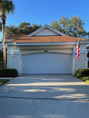 Two-car garage with beach bikes and a variety of pool and beach toys.