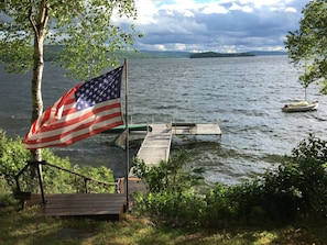 Breathtaking view of dock, lake, island and distant mountians from front yard.