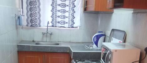 kitchenette with ample storage and fully equipped with crockery and cutlery 