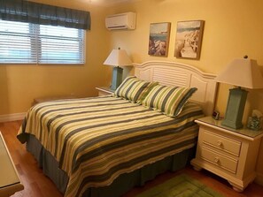 The master bedroom has generous clothing storage , a tv, and master bedroom bath