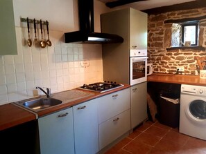Kitchen with full size fridge, oven, microwave, washing machine.