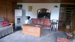 Stube mit 3 Sofagruppen, Lesestuhle und Chemineofen.