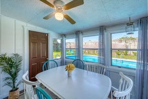 The dining room is a light and bright Florida Room space overlooking the pool.