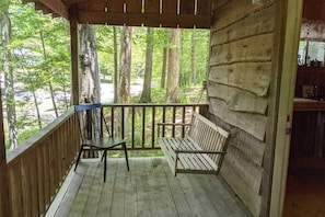"Flatts" deluxe camping cabin back porch with swing.