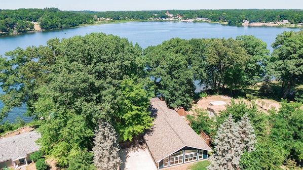 The Cedar Lodge (partially hidden by trees) sits atop beautiful Stone Lake.