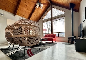 Comfortable, cozy living room with wood stove and large windows