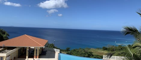 Infinity pool and ocean view from condo balcony.