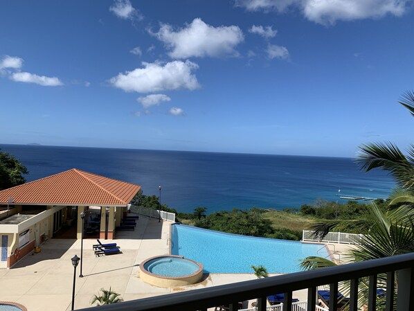 Infinity pool and ocean view from condo balcony.