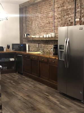 Kitchen area with microwave, coffee pot, and dishware