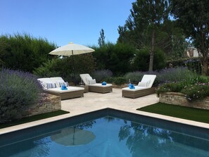 Sunny seating area alongside the pool