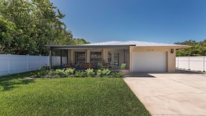 Front of house with screened lanai and privacy fence 