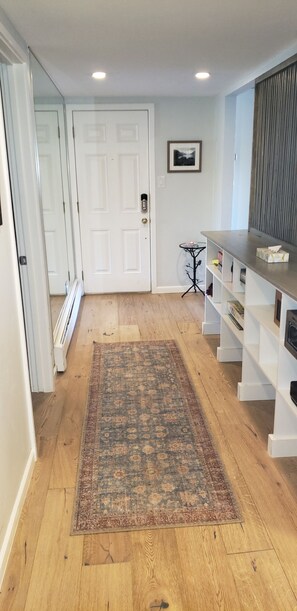 entrance way to condo.  Shelving w/ space for ski helmets/boots . 