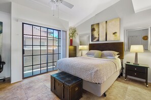 The main floor bedroom features a queen bed overlooking a sunny balcony