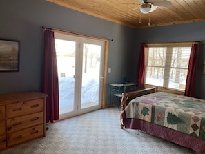 Main bedroom w queen bed & work space.  Patio doors that look out on the lake!