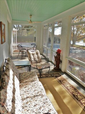 Relax on the screened porch with views of the pool and creek.