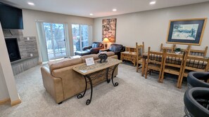 Living room with sofa bed, gas fireplace, and balcony w/ propane BBQ grill