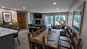 Living room with sofa bed, gas fireplace, dining table, and balcony w/ gas BBQ