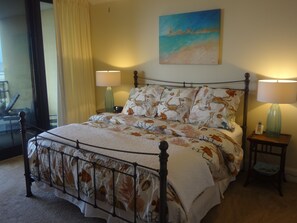 Luxurious king bed in master bedroom with flat screen TV and private bathroom.