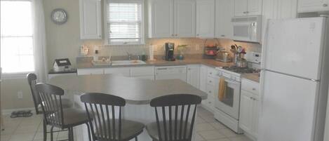 Kitchen with adjacent dining room both open to living room