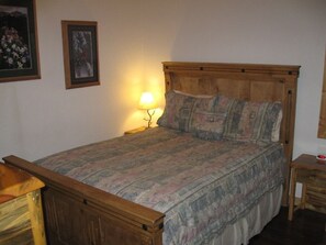 Queen bed in the enclosed bedroom downstairs