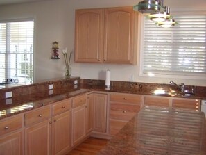 Open and spacious kitchen with all you need.  Barstools make it easy to serve.
