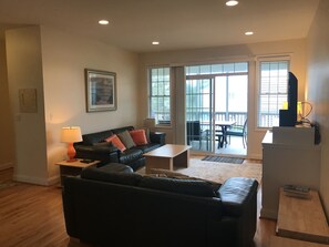 Living room w/ access to screened-in porch w/ grill and outdoor dining 