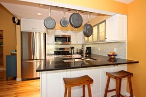 Our Kitchen showing dbl door fridge, microwave & range with stove top griddle